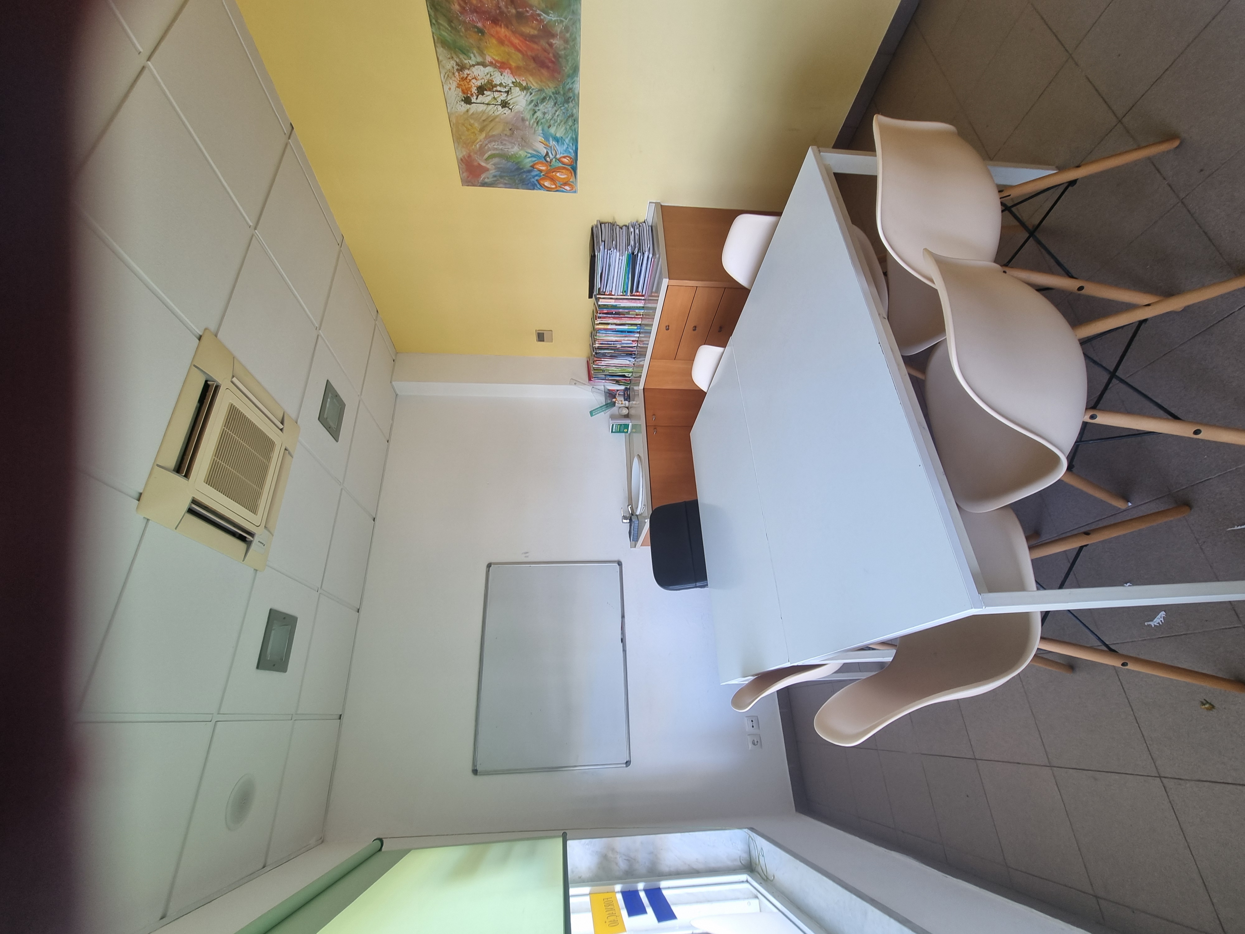 Sala com quadro e mesa de grupo